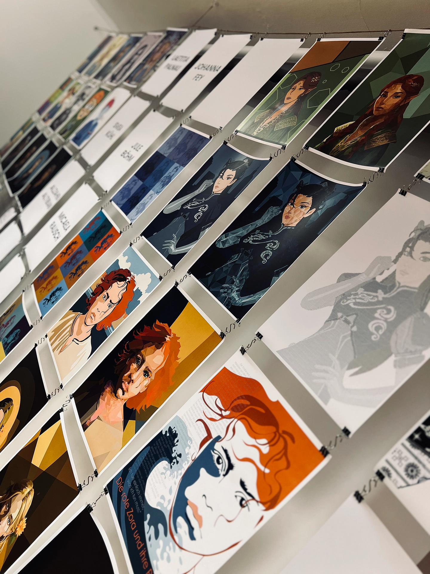 Große Ausstellungswand mit zahlreichen digital illustrierten Charakterporträts in unterschiedlichen Stilen, unter anderem das Motiv „Die rote Zora und ihre Bande"